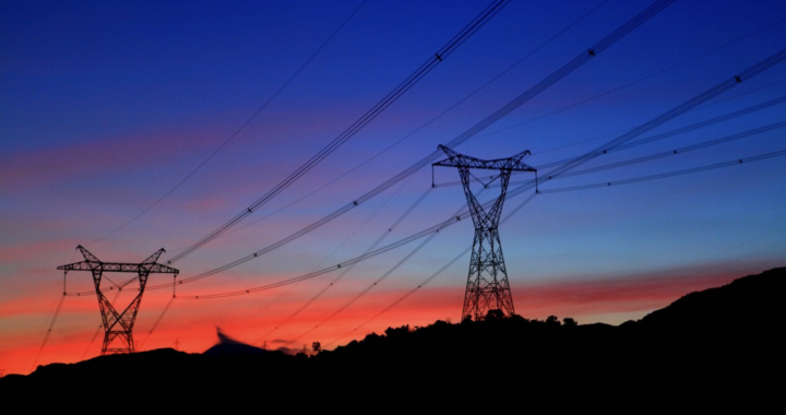 Fotografía en color de torres de transmisión de energía al atardecer.
