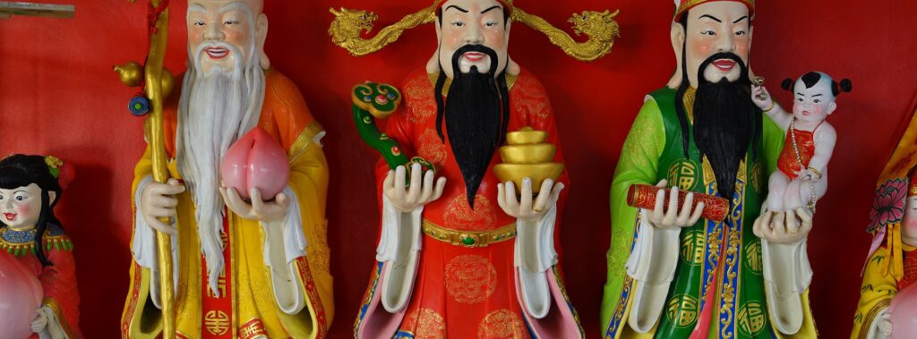 Fotografia em cores de estátuas de Fu Xing, Lu Xing e Shou Xing, deuses da fortuna, prosperidade e longevidade