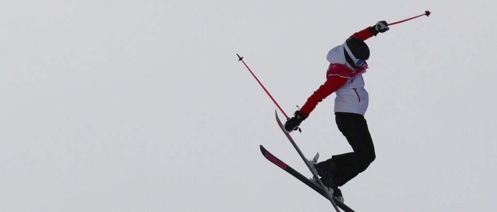 Fotografía en color de la esquiadora Eileen Gu suspendida en el aire, con los brazos extendidos, durante los Juegos Olímpicos de la Juventud 2020.