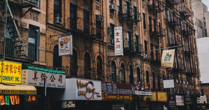 Fotografia em cores mostrando fachada de prédios e lojas na Chinatown de Nova Iorque, Estados Unidos,