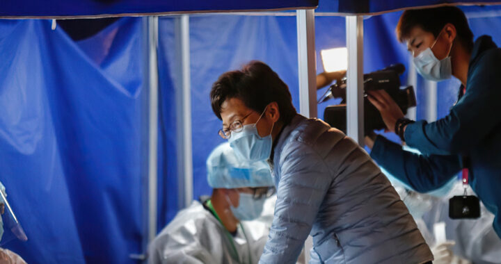 Fotografia em cores da CEO de Hong Kong Carrie Lam, visitando um posto de testagem contra a Covid-19. Carrie Lam está usando uma máscara cirúrgica.