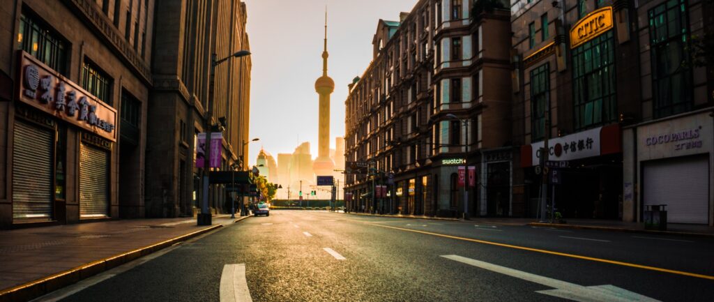 Fotocromía. Muestra una calle vacía de shanghai bajo el sol naciente. Al fondo se puede ver la famosa torre de la Perla Oriental.