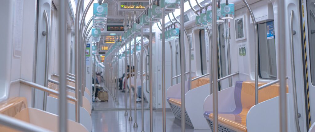 Fotografía en color de un vagón de tren en Shanghai. El vagón está casi vacío, con solo unas pocas personas al fondo.