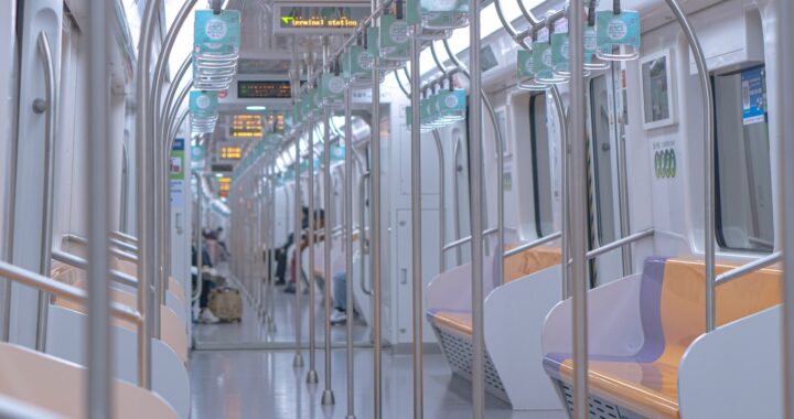 Fotografía en color de un vagón de tren en Shanghai. El vagón está casi vacío, con solo unas pocas personas al fondo.