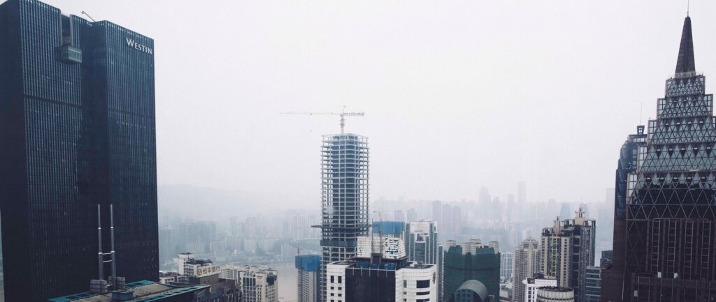 Fotografia em cores arranha-céus na cidade chinesa de Chongqing. No centro da foto, ao longe, um prédio em construção.