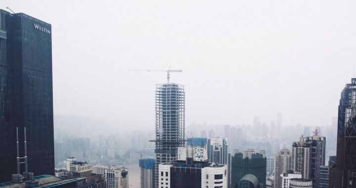 Fotografia em cores arranha-céus na cidade chinesa de Chongqing. No centro da foto, ao longe, um prédio em construção.