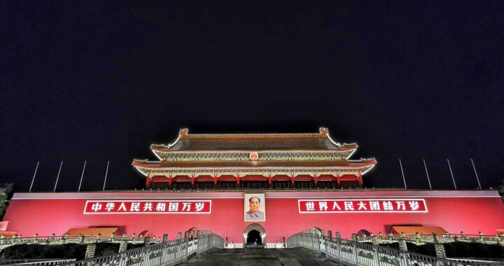 Fotografia em cores da Porta de Tiananmen iluminada à noite.