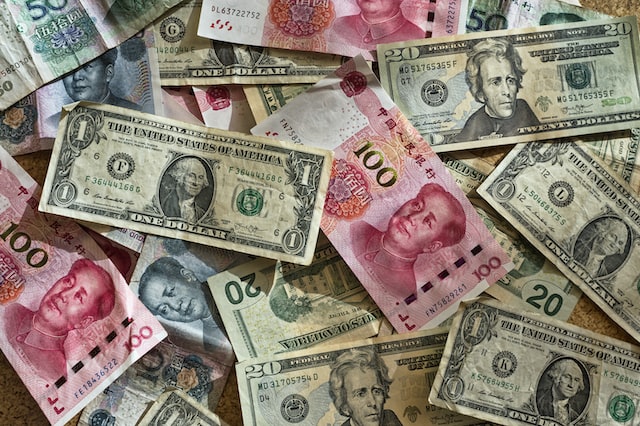 Fotografia em cores de notas de renminbi e dólar estadunidense.