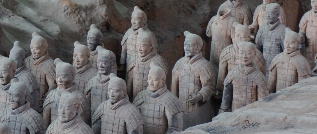 Fotografia em cores dos guerreiros de terracota chineses – três filas de estátuas de guerreiros chineses, feitas de terracota.