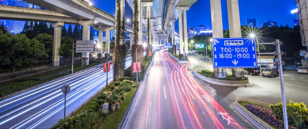 Carros passando em avenidas de Shanghai à noite