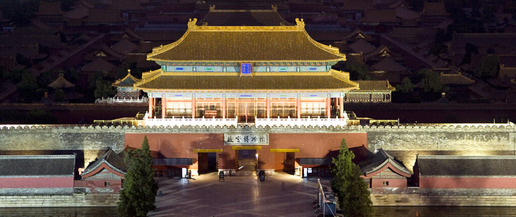 Fotografia em cores de vista aérea da Cidade Proibida iluminada à noite.