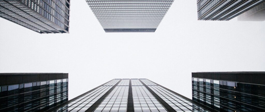 foto em preto em branco tirada de baixo para cima mostrando arranha-céus