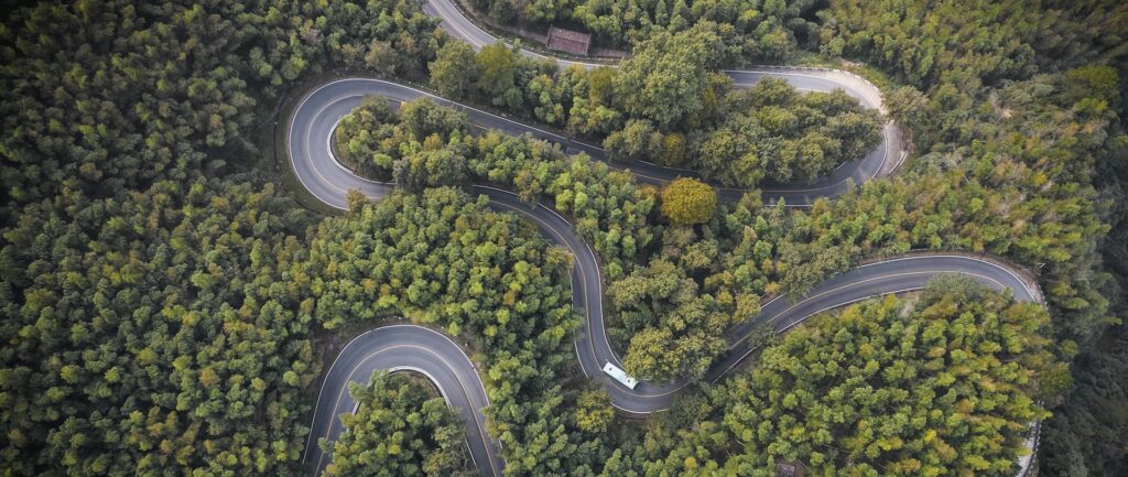 Fotografia em cores de estrada sinuosa em meio a árvores na China