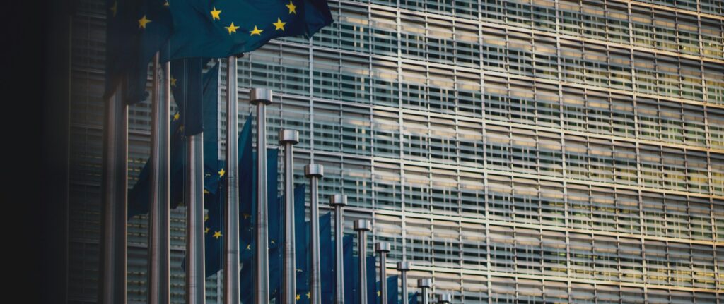 Fotografia em cores de sequência de bandeiras da união europeia na fachada do prédio do órgão em Bruxelas.