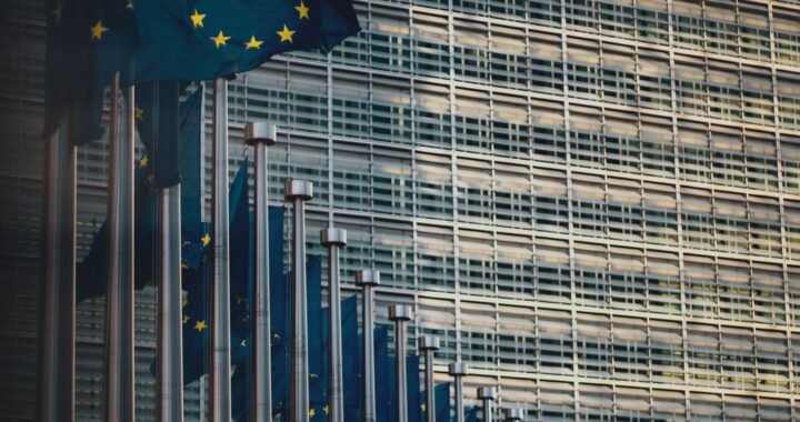 Fotografia em cores de sequência de bandeiras da união europeia na fachada do prédio do órgão em Bruxelas.