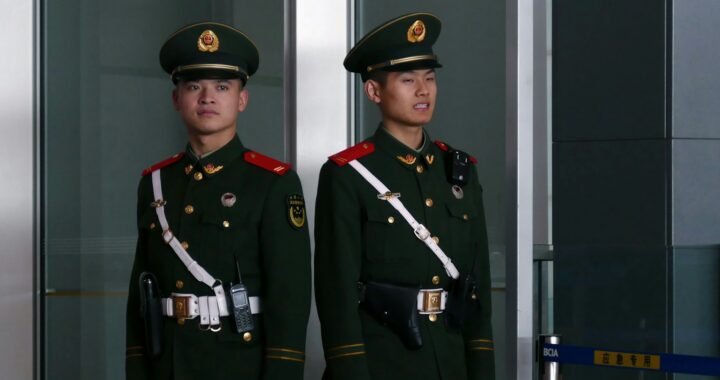 Fotografia em cores de dois soldados do Exército de Libertação Popular.