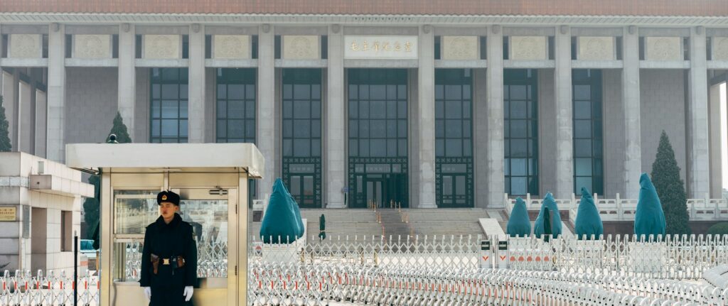 Fotografia em cores de militar fazendo a guarda de um prédio público em Pequim.