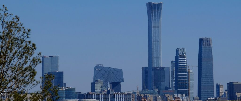 Foto do horizonte do centro financeiro da cidade de Pequim, com vários arranha-céus e um céu azul.