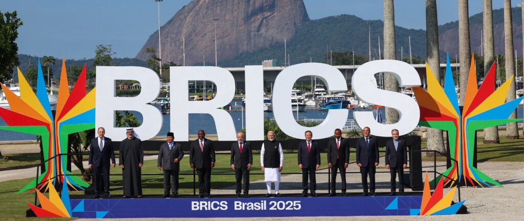 Fotografia em cores dos líderes dos países membros dos BRICS no Rio de Janeiro em julho de 2025, com o Pão de Açúcar ao fundo.