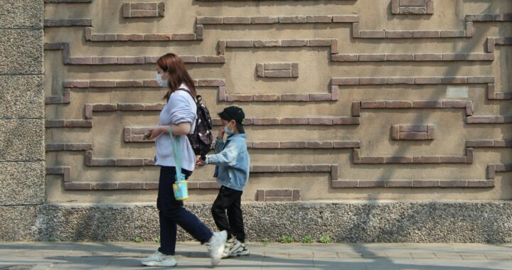 Uma mulher e uma criança caminhando por uma calçada foto