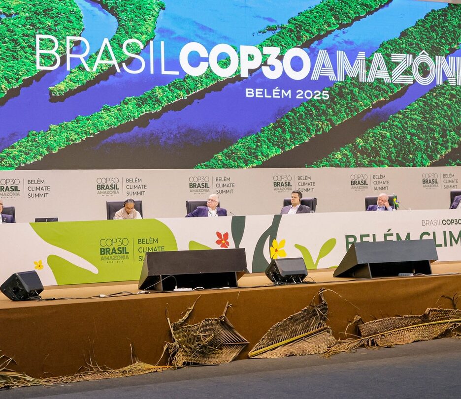 Fotografia da abertura da Plenária da COP30, com uma mesa branca e um painel grande ao fundo dizendo Brasil COP30 Amazônia