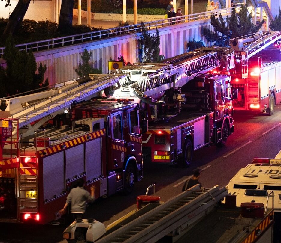 Foto de caminhões de bombeiros e veículos de emergência em frente ao Wang Fuk Court em Hong Kong