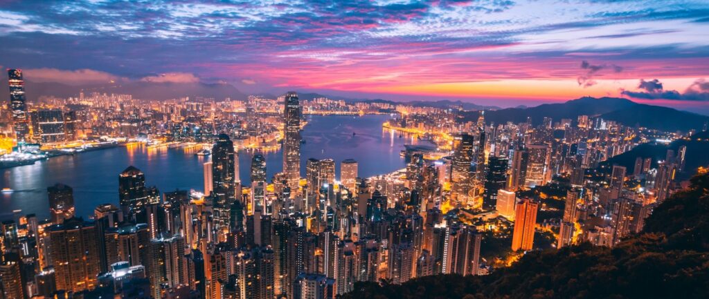 Fotografia em cores de por do sol arroxeado na baía de Hong Kong.