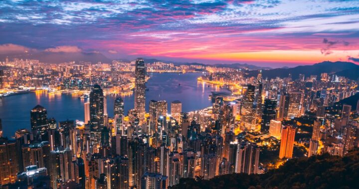 Fotografia em cores de por do sol arroxeado na baía de Hong Kong.