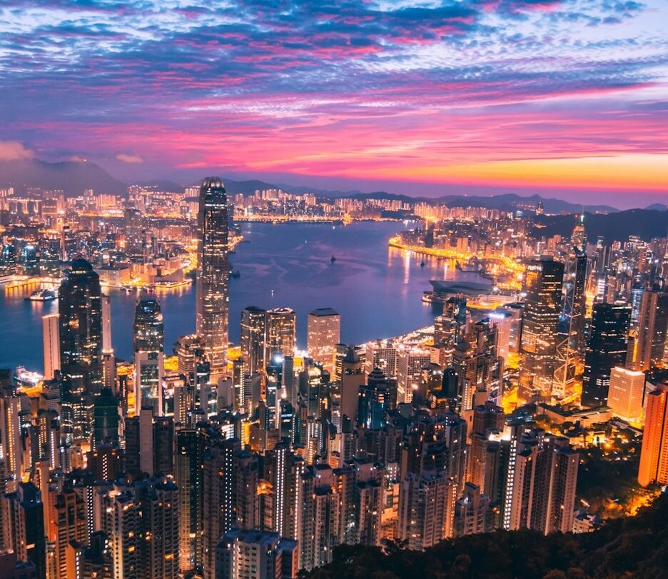 Fotografia em cores de por do sol arroxeado na baía de Hong Kong.