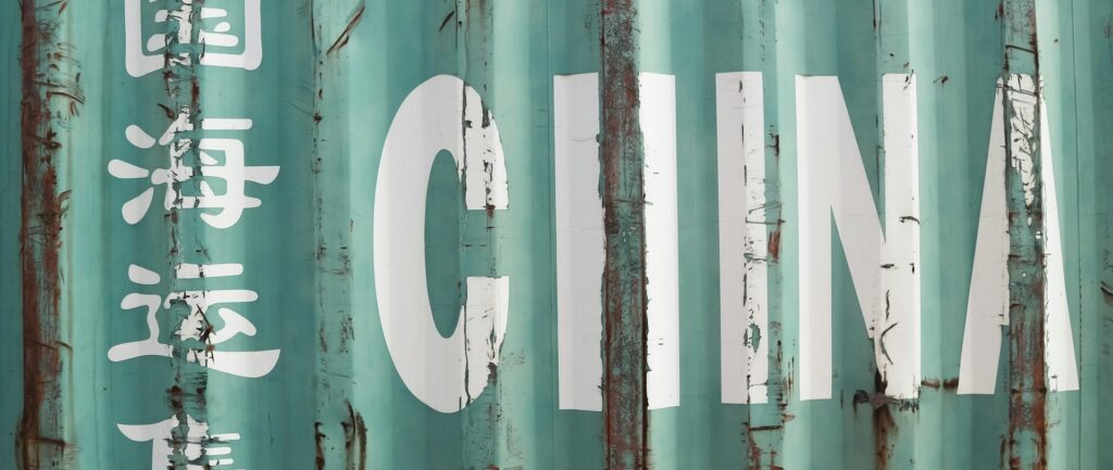 Fotografia em cores de um container verde claro com a palavra China escrita em destaque e alguns caracteres chineses.