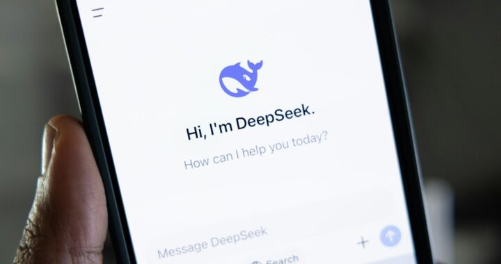 Fotografia em cores de um celular na mão de uma pessoa; o aplicativo aberto no celular é o DeepSeek.